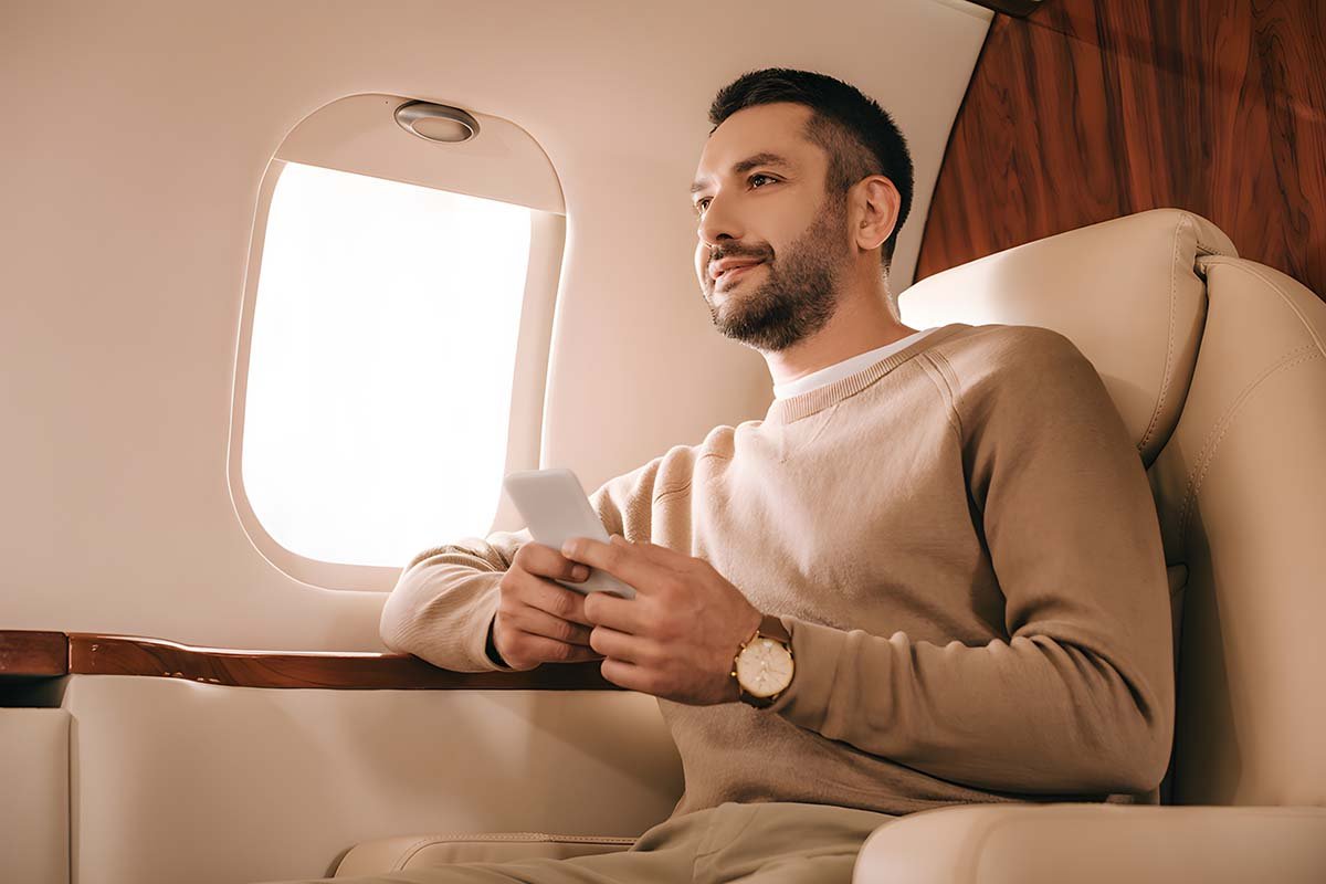 Passenger using a cellphone on his private charter flight in the Caribbean.